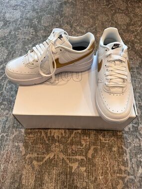 NIKE Air Force 1 Unisex White Sneakers with Gold Swoosh